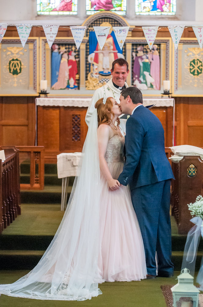 Bride and groom kiss in ceremony, Burley in Wharfedale church, Yorkshire wedding photographers