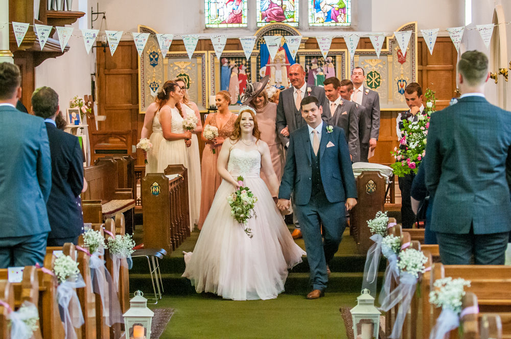 Bride and groom walking back down aisle in church, Burley in Wharfedale church, Yorkshire wedding photographers