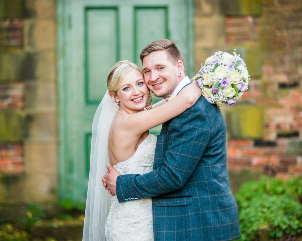 Bride and groom posing by green door in grounds, Wortley Hall, Sheffield wedding photography