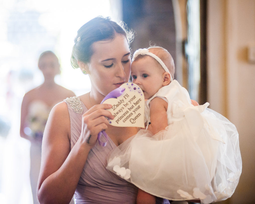 Bridesmaid with bride and groom's daughter walking down the aisle with personalised sign, Wortley Hall, Sheffield wedding photography