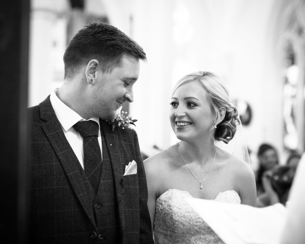 Groom smiling at bride at top of aisle, Wortley Hall, Sheffield wedding photography