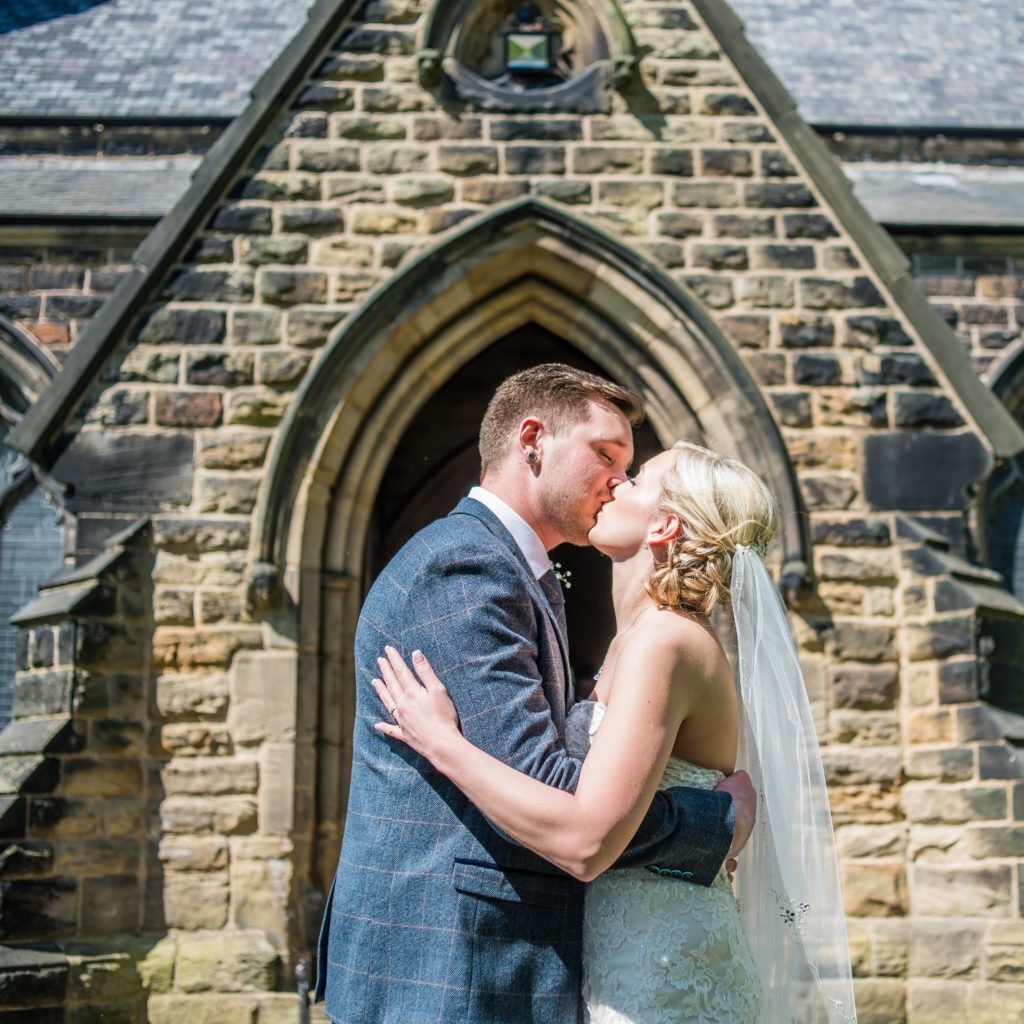 Bride and groom kiss outside church, Wortley Hall, Sheffield wedding photography