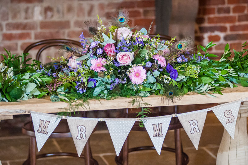 Joelle & Scott's table top flower arrangement with peacock feathers for their Sheffield wedding at Hazel Gap Barn