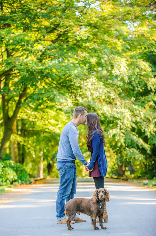 Rochelle and Oliver kissing with dog looking on pre-wedding portraits, Whirlowbrook Hall, Sheffield