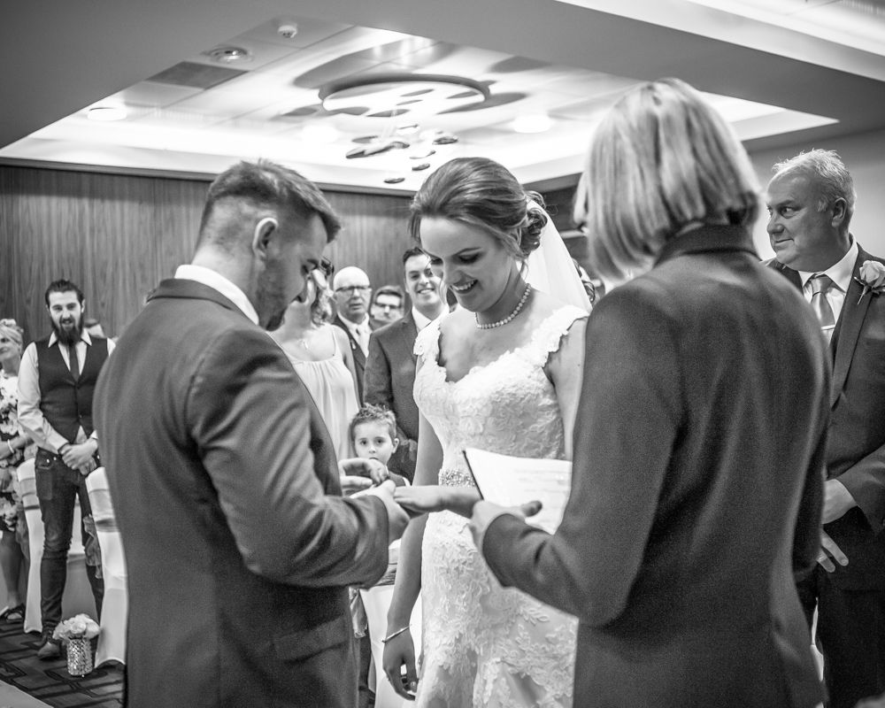 Groom putting ring on brides finger, Chesterfield wedding photographer, Casa Hotel