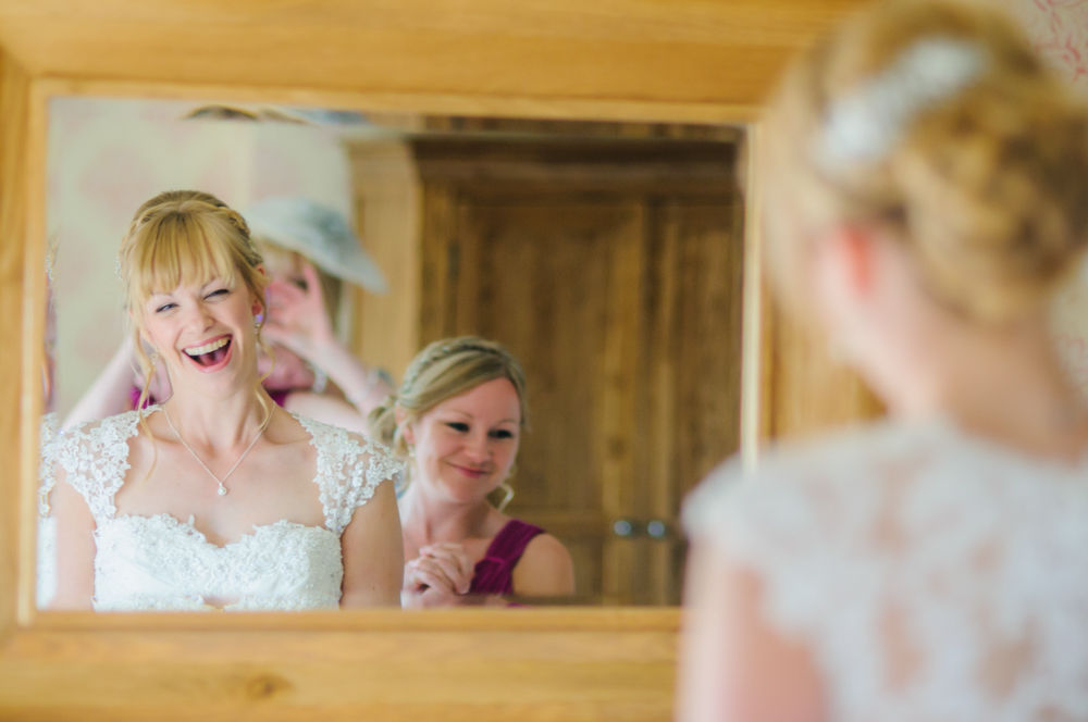 Bride laughing in mirror, Sheffield wedding photographers, Smallshaw Farm Cottages