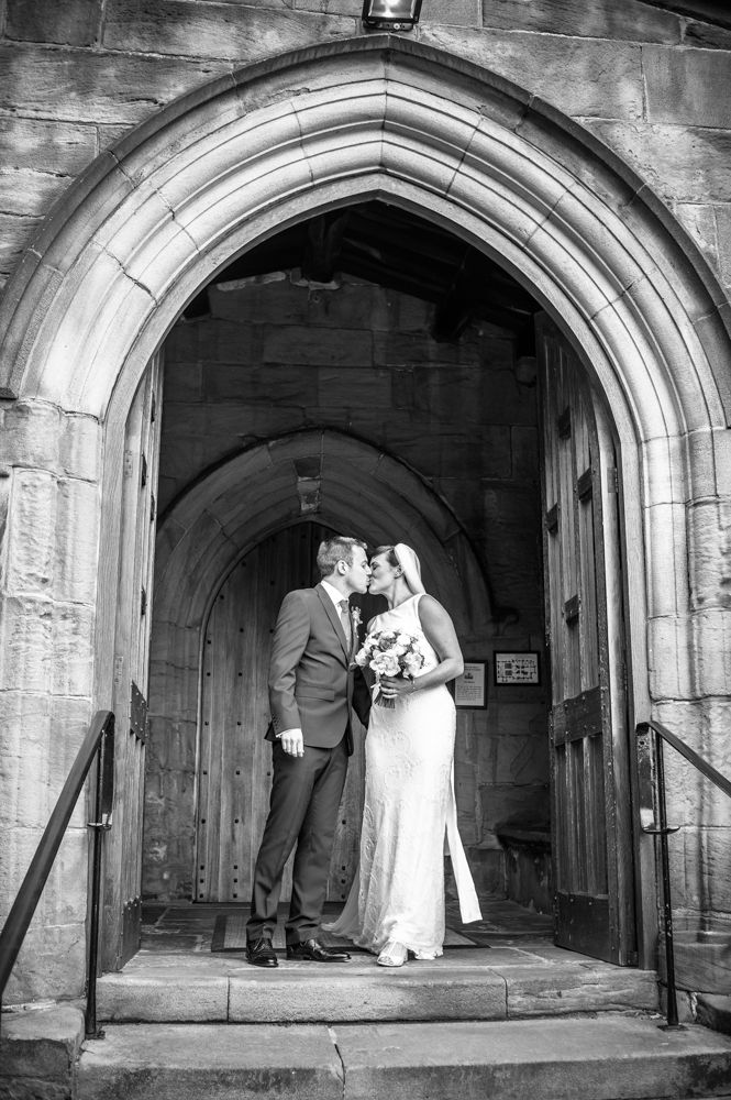 Bride and groom kissing on church steps, Ecclesfield Church Sheffield
