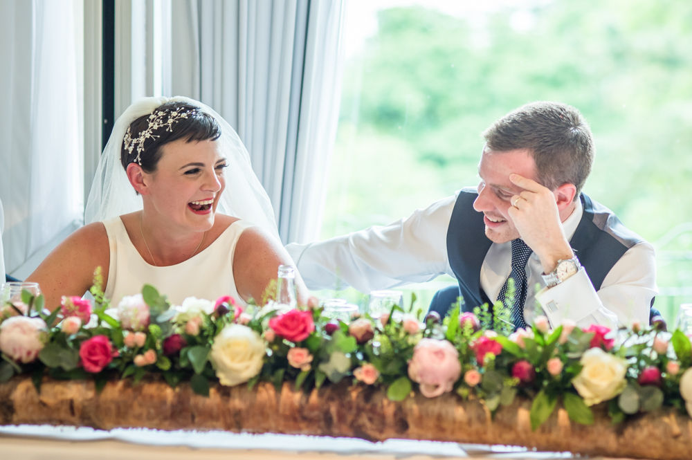 Groom and bride laughing during speeches, Sheffield wedding photographers, Whirlowbrook Hall