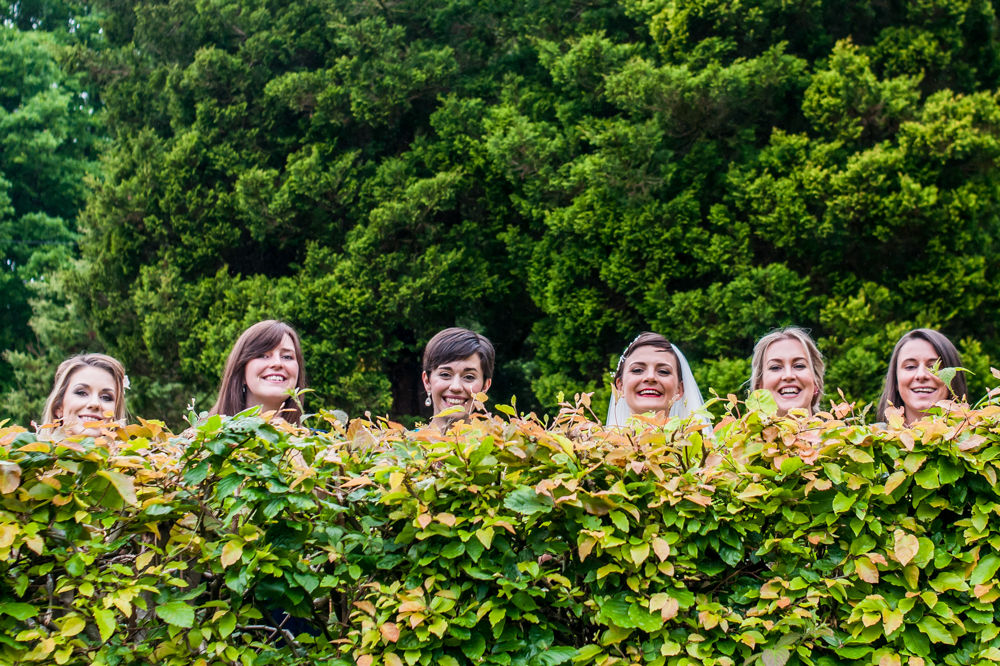 Bride and friends peeping over hedge, Sheffield wedding photographers, Whirlowbrook Hall