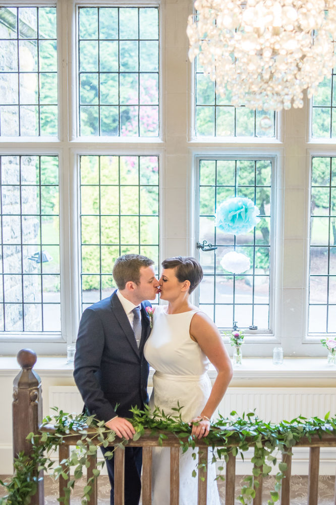 Bride and groom kissing on stairs, Sheffield wedding photographers, Whirlowbrook Hall