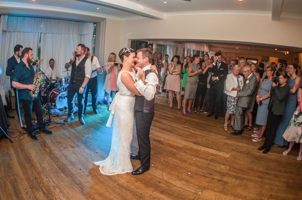 Bride and groom first dance with guests in background, Sheffield wedding photographers, Whirlowbrook Hall