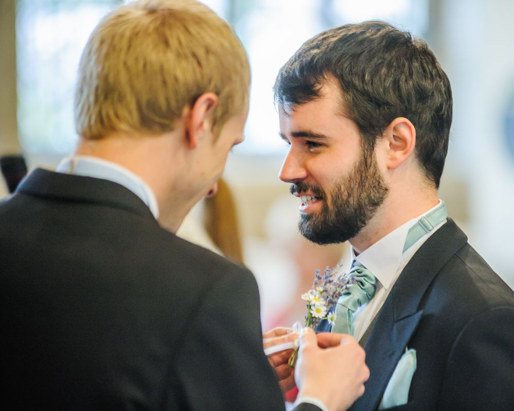 Groom adjusting buttonhole, Sheffield wedding photographers