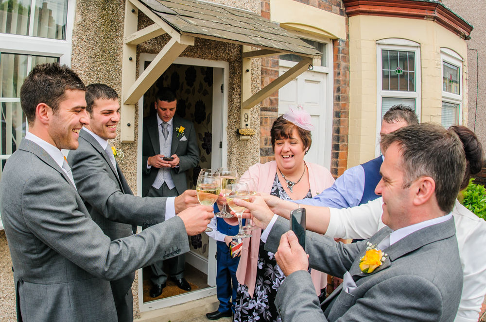 Groom and family cheers - Cumbria wedding photographers