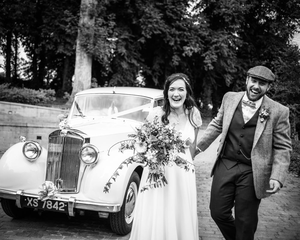 Laughing by wedding car,  Wentworth Castle Garden wedding, Sheffield photographers