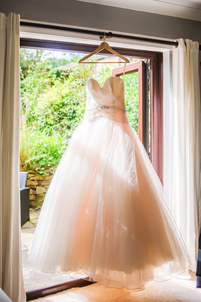 Emma's wedding dress hanging in window, Maynard wedding, Sheffield photographers