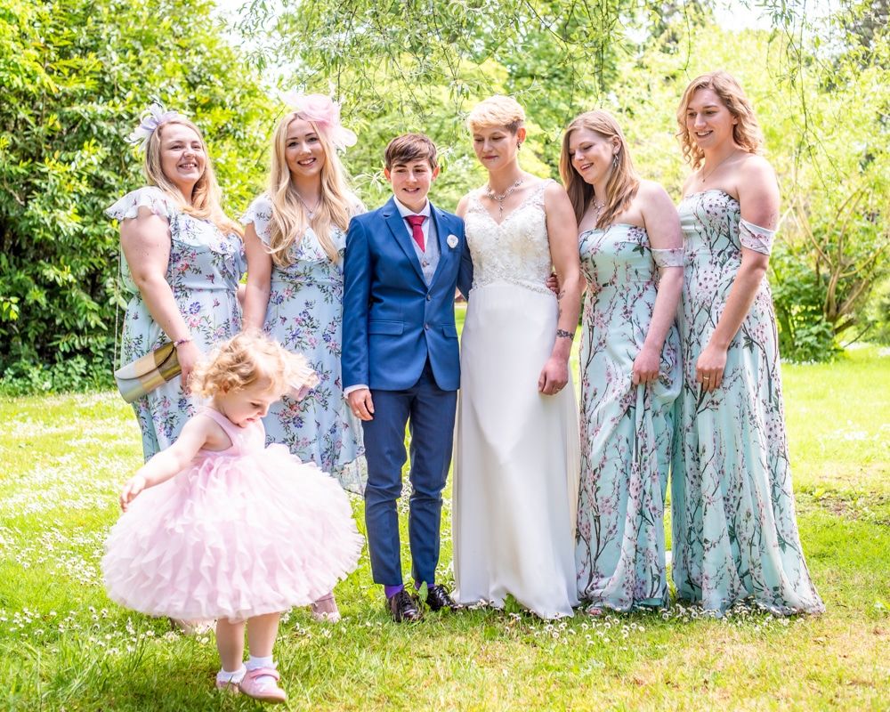 Flower girl showing off in group photo, Carlisle Register office, Lake District wedding photography