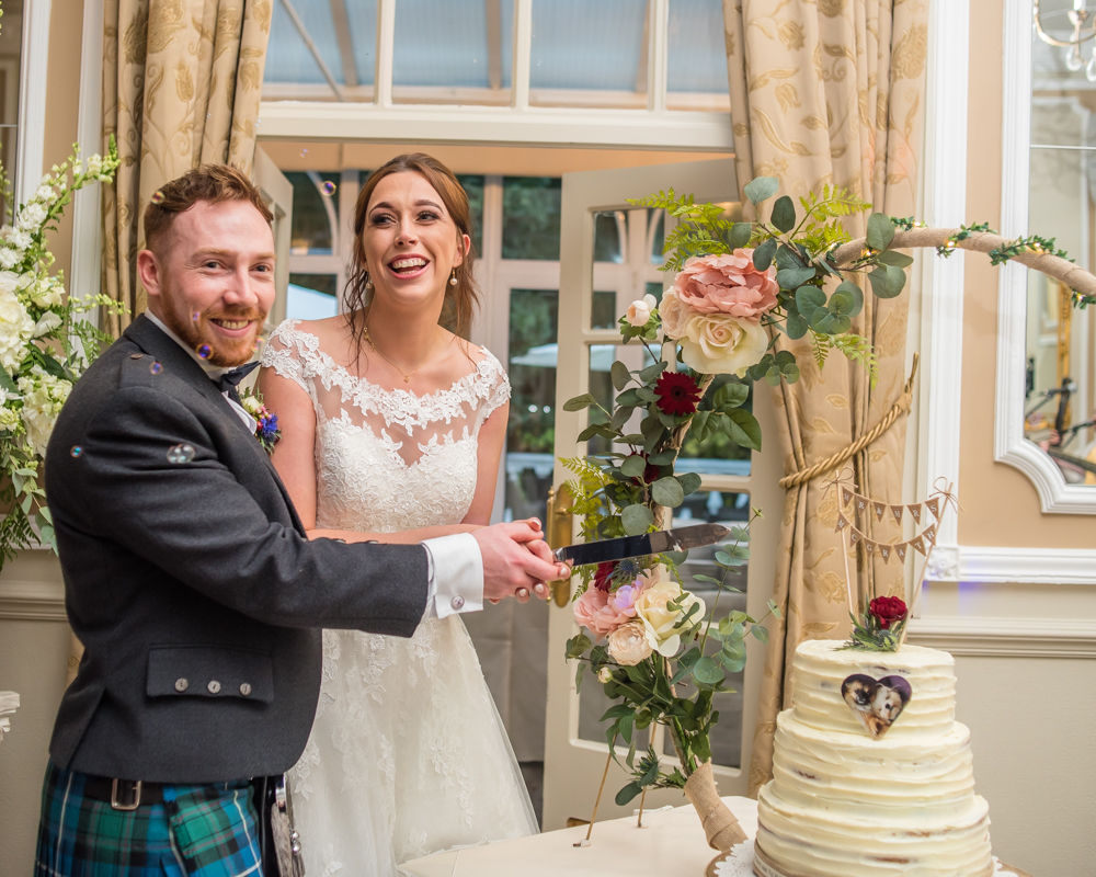 Laughing while about to cut the wedding cake, Sheffield wedding photographers, Ringwood Hall Hotel