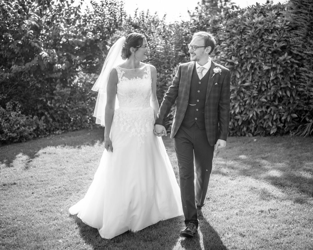 Bride and groom walking in grounds, Shireburn Arms, Lancashire wedding photographers