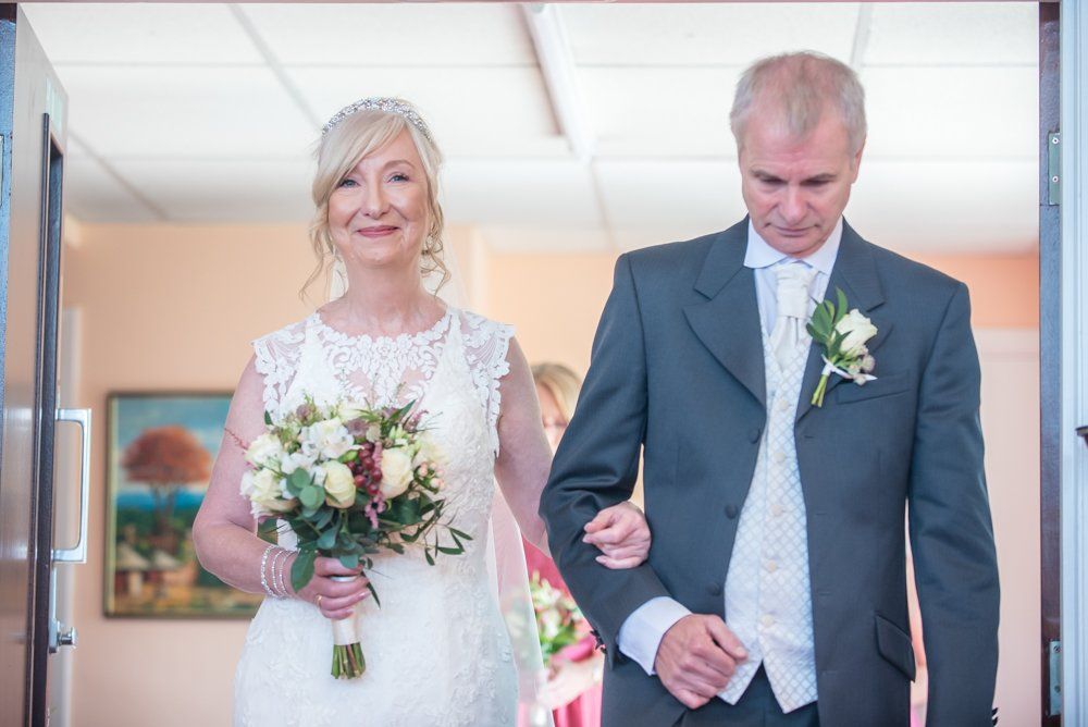 Caroline walking down aisle with her brother, Hotel Van Dyk wedding photography Chesterfield