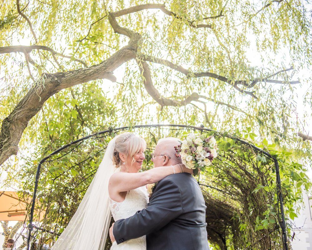 Under the tree arch at the wedding venue,  Hotel Van Dyk wedding photography Chesterfield
