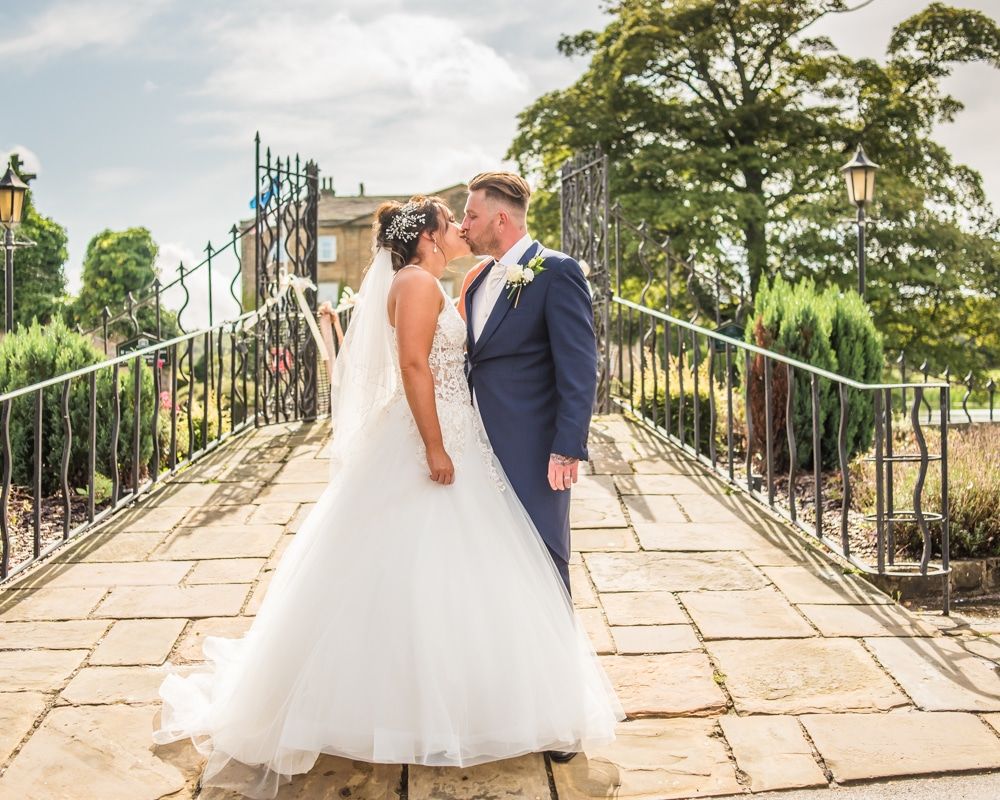 Kisses with bridge in the background, Waterton Park Hotel weddings, Yorkshire wedding photographers
