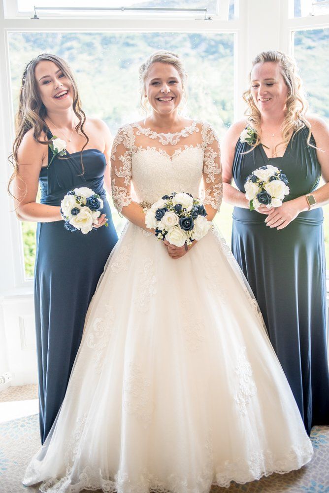 Bride and bridesmaids posing in window, Inn on the Lake Weddings, Lake District