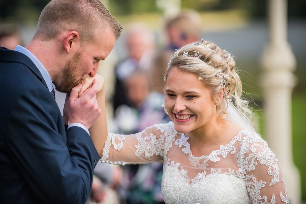 Groom kissing bride on hand, Inn on the Lake Weddings, Lake District