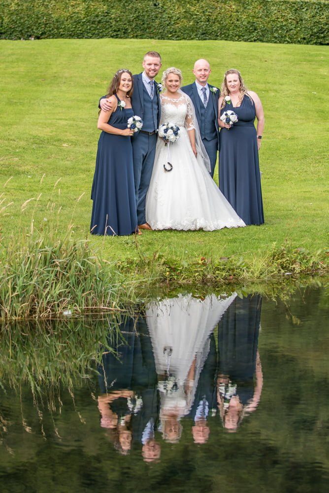 Bridal party reflection in mirror lake, Inn on the Lake Weddings, Lake District