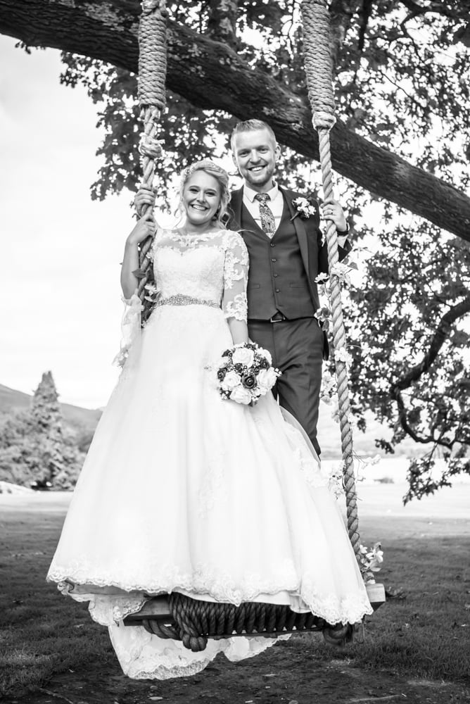 Happy couple squeezing onto the swing, Inn on the Lake Weddings, Lake District