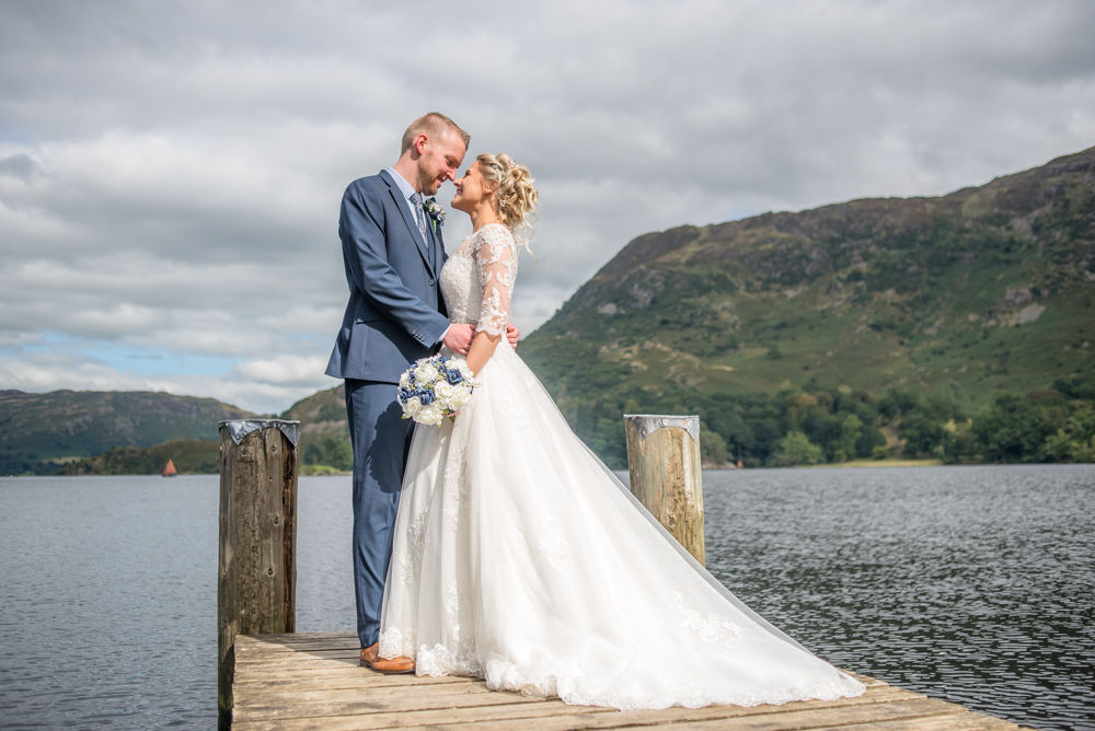 Bride and groom posing with fells in background, Inn on the Lake, Ullswater, Lake District documentary wedding photographers