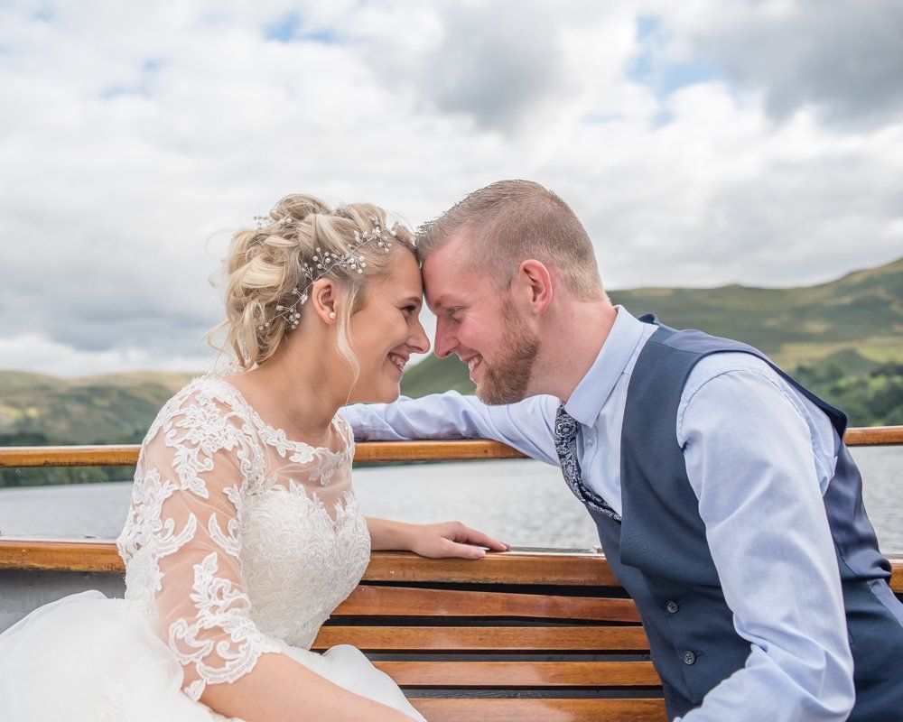 Looking at each other on boat, Inn on the Lake Weddings, Lake District