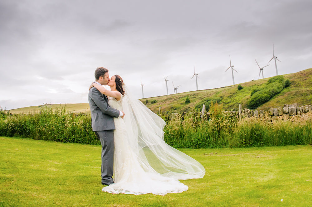 Laura and Simon kiss in field, Smallshaw Farm Cottages weddings, Sheffield wedding photography