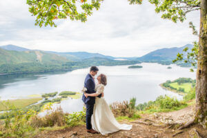 Bride and groom pose at Surprise View with views of Derwentwater at the Lake District