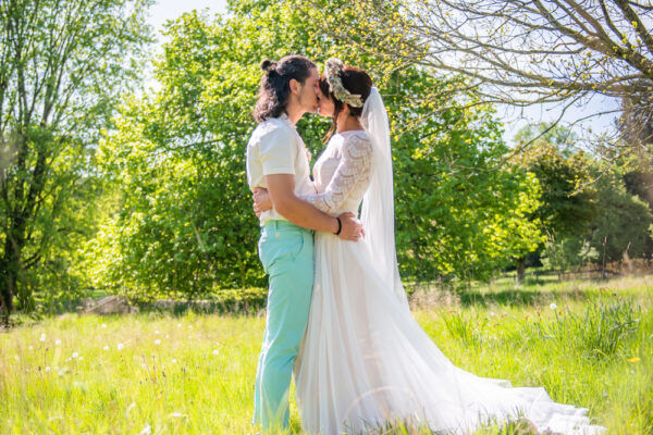 Bride and groom kiss in field, Edenhall estate wedding, Penrith Lake District wedding photographers