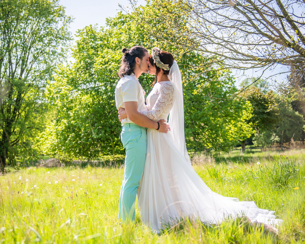 Bride and groom kiss in field, Edenhall estate wedding, Penrith Lake District wedding photographers
