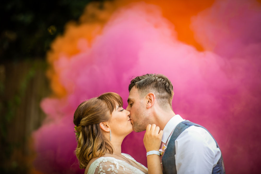 Bride and groom kiss in front of smoke, Mosborough Hall wedding photographers Sheffield