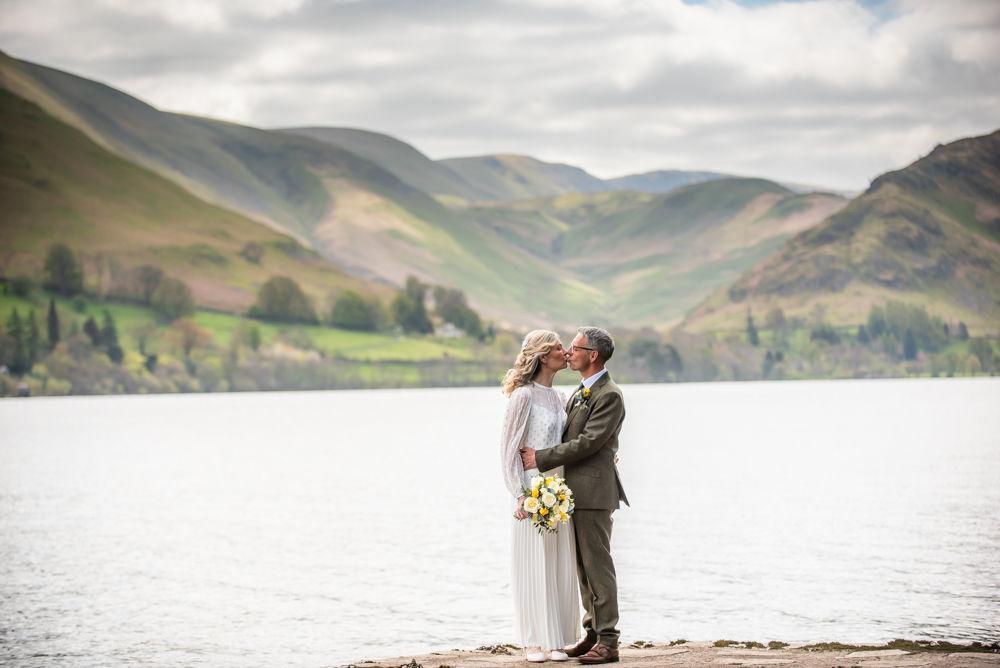 Bride and groom kiss by Ullswater Lake, Far Boathouse weddings, Ullswater, Lake District