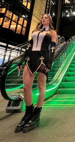 Full-body Halloween nun costume with a bold black-and-white silhouette, cross details, and platform boots.
