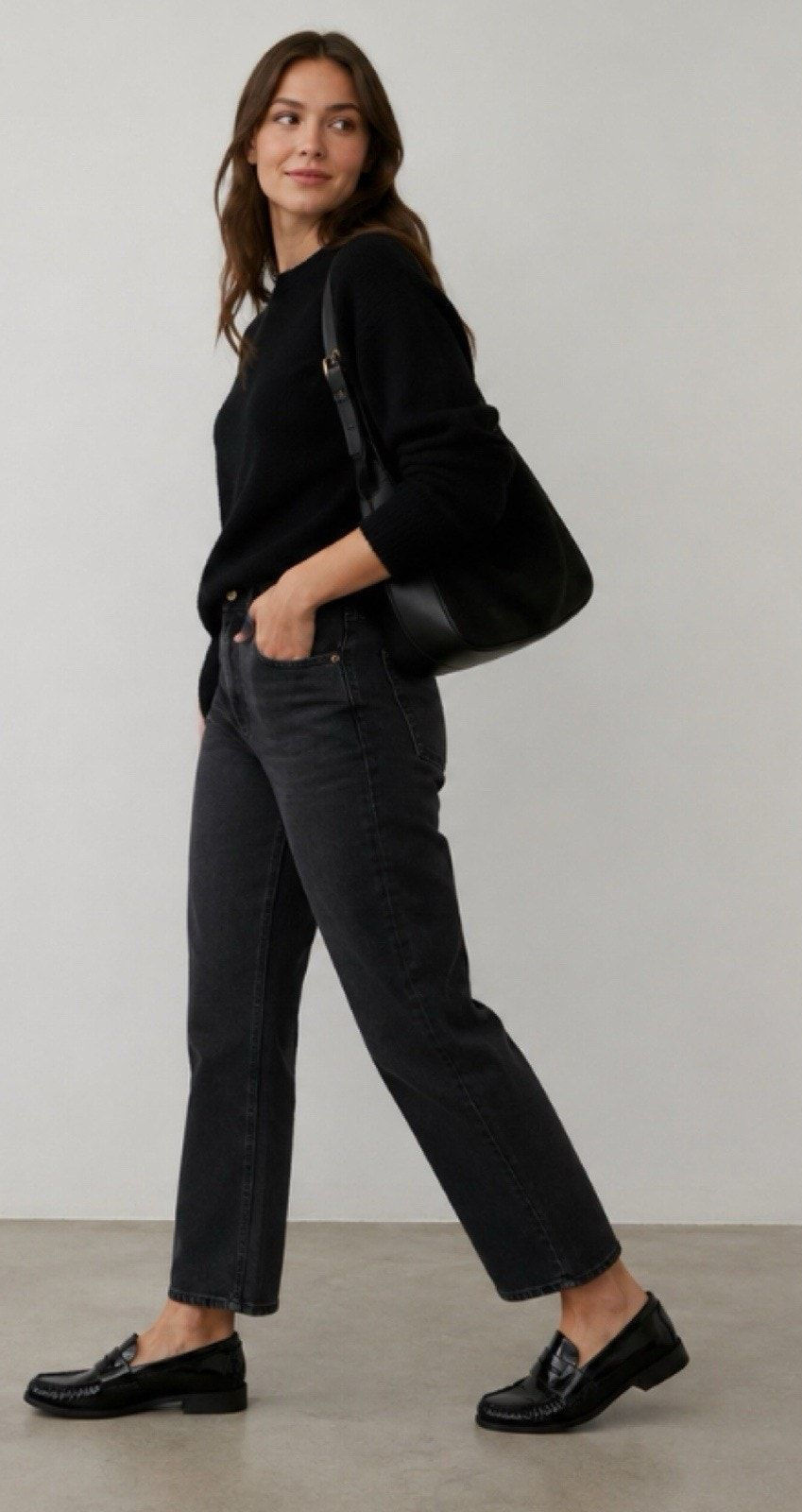 Black patent leather penny loafers styled with tailored black trousers.