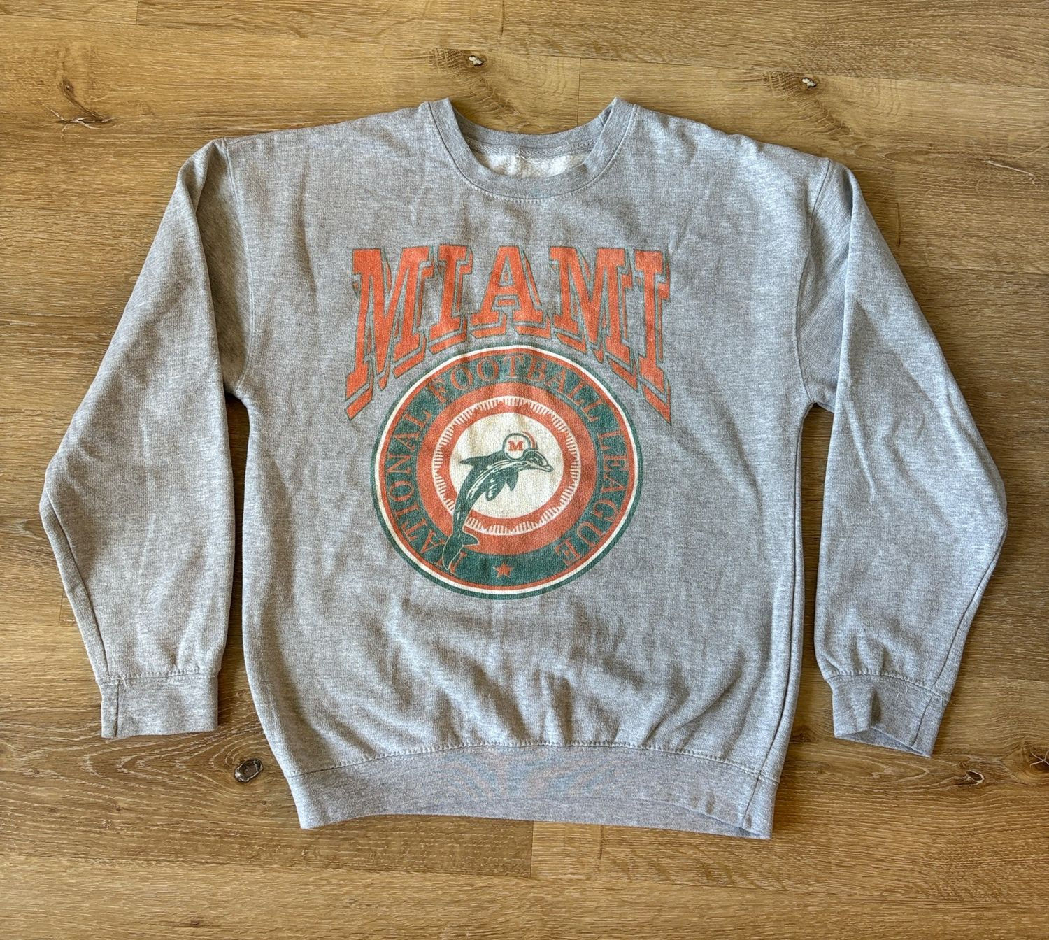 Faded gray vintage Miami Dolphins crewneck sweatshirt with a softly worn graphic.
