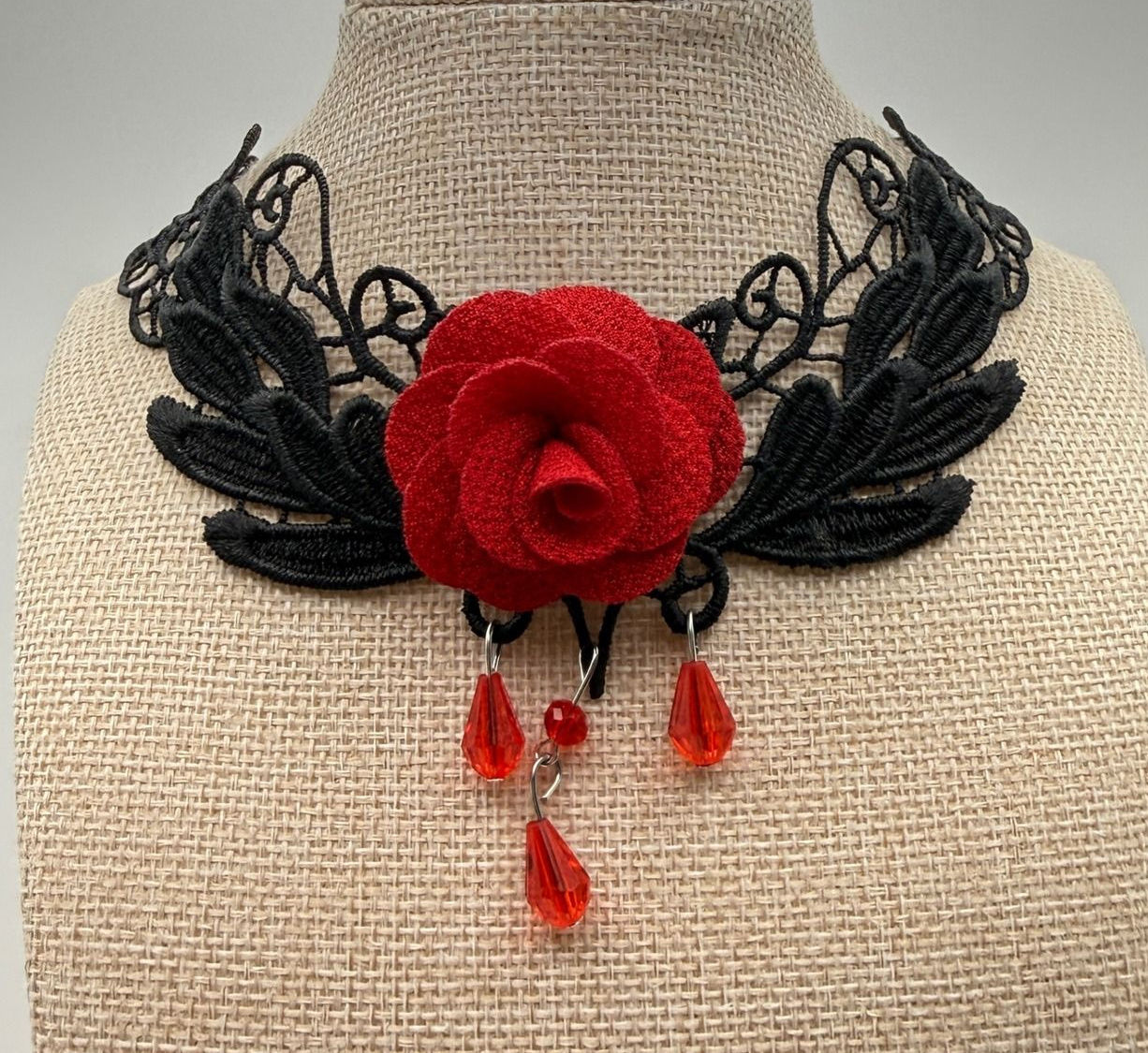 Black lace gothic choker with a red rose centerpiece and dangling red beads.