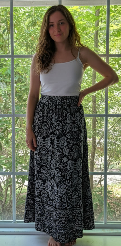 Full-length black floral maxi skirt styled with a white tank, showing its flowing silhouette.