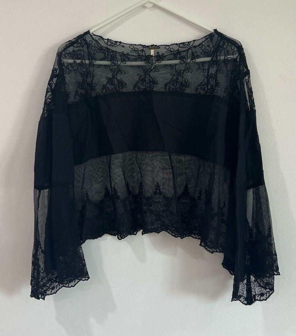 Black sheer floral-lace blouse with dramatic bell sleeves and a scalloped hem.