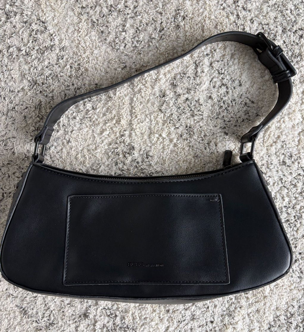 Black baguette shoulder bag with a slim strap, zip-top closure, and visible stitched corners.
