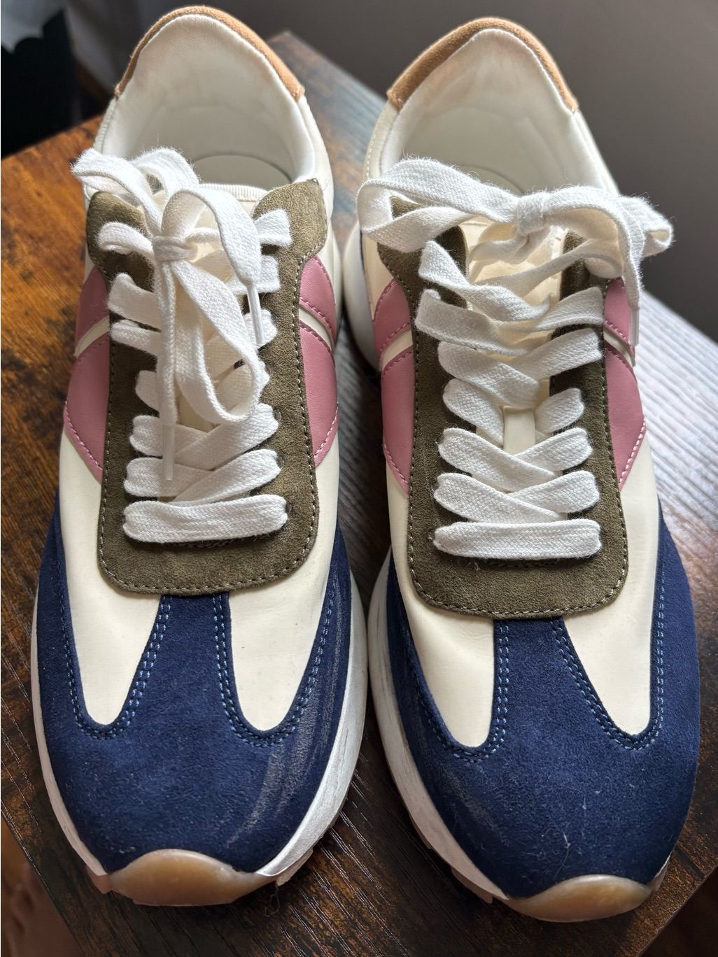 White and navy retro sneakers with olive and pink accents in a gently worn seller photo.