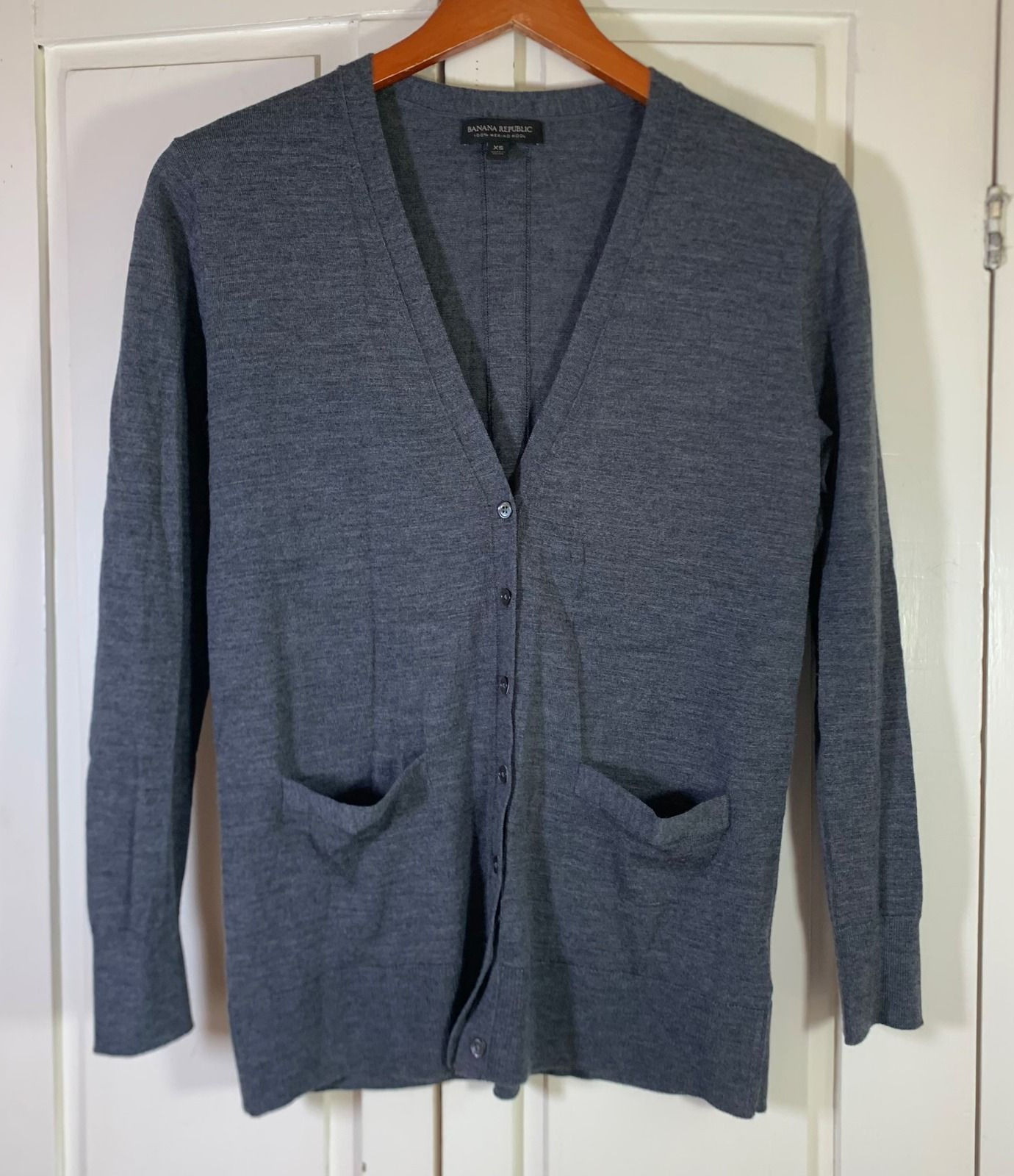 Gray merino wool V-neck cardigan with a button front and patch pockets.
