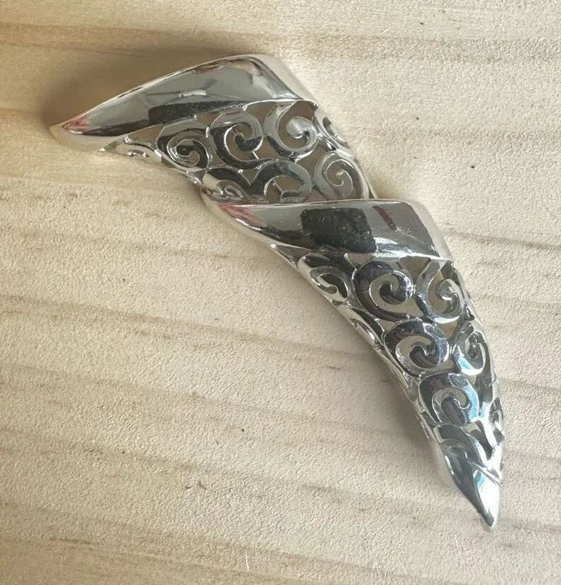 Ornate silver-tone filigree swirl brooch with an antique-inspired design.