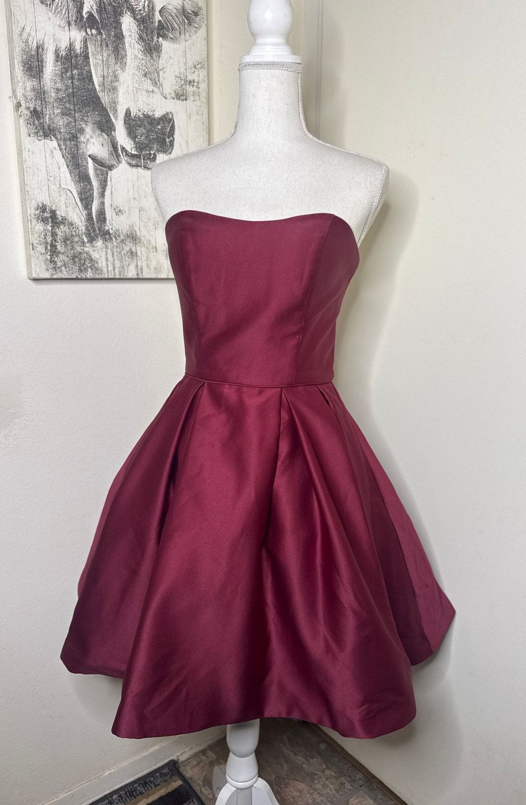 Strapless berry satin dress with a defined bodice and full pleated skirt.
