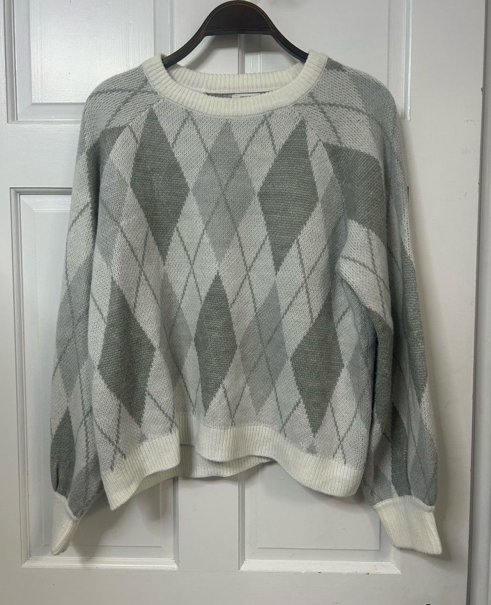 Gray and white argyle crewneck sweater with long sleeves.