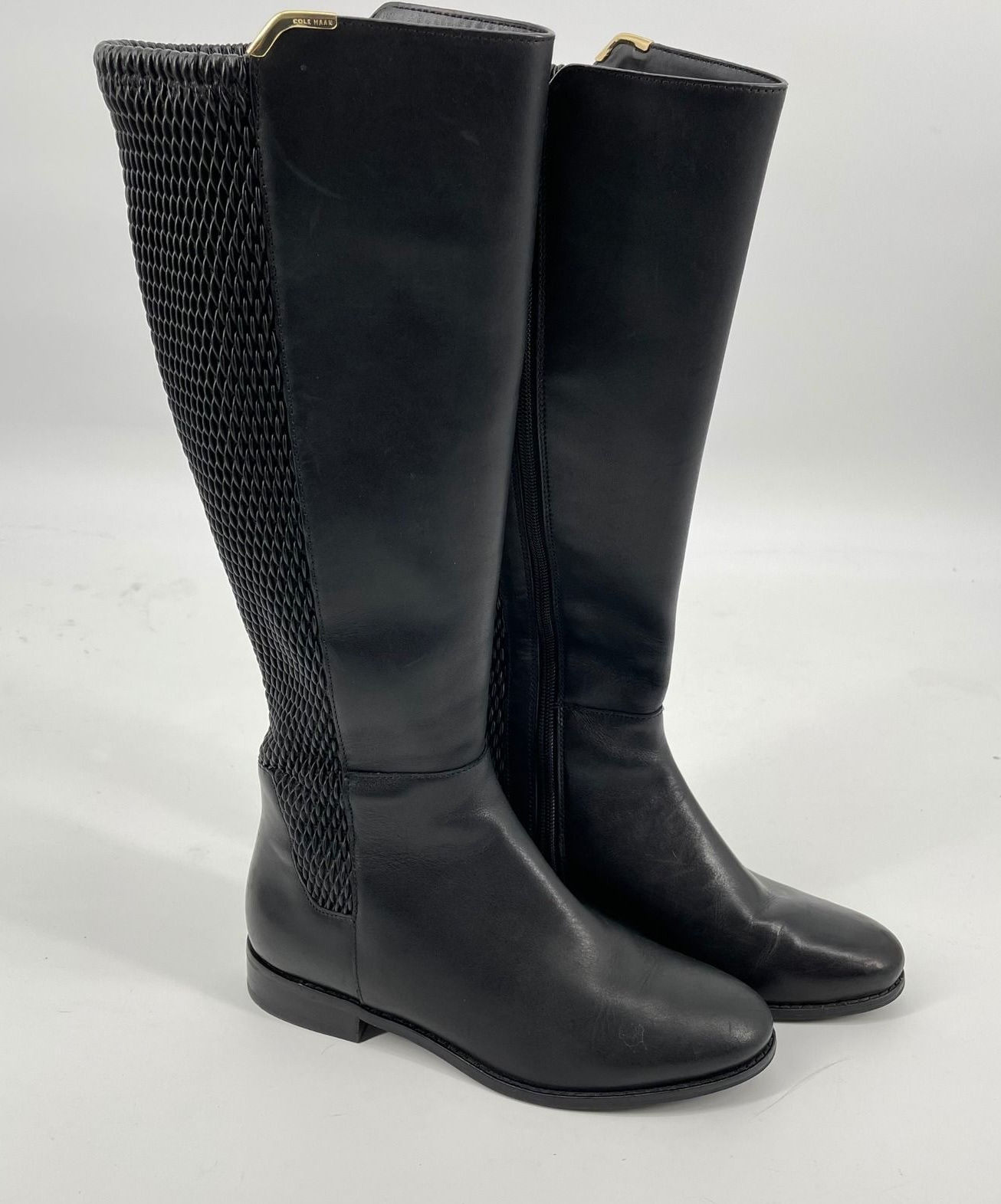 Black leather knee-high riding boots with a sleek structured shaft, low heel, and minimal detailing.